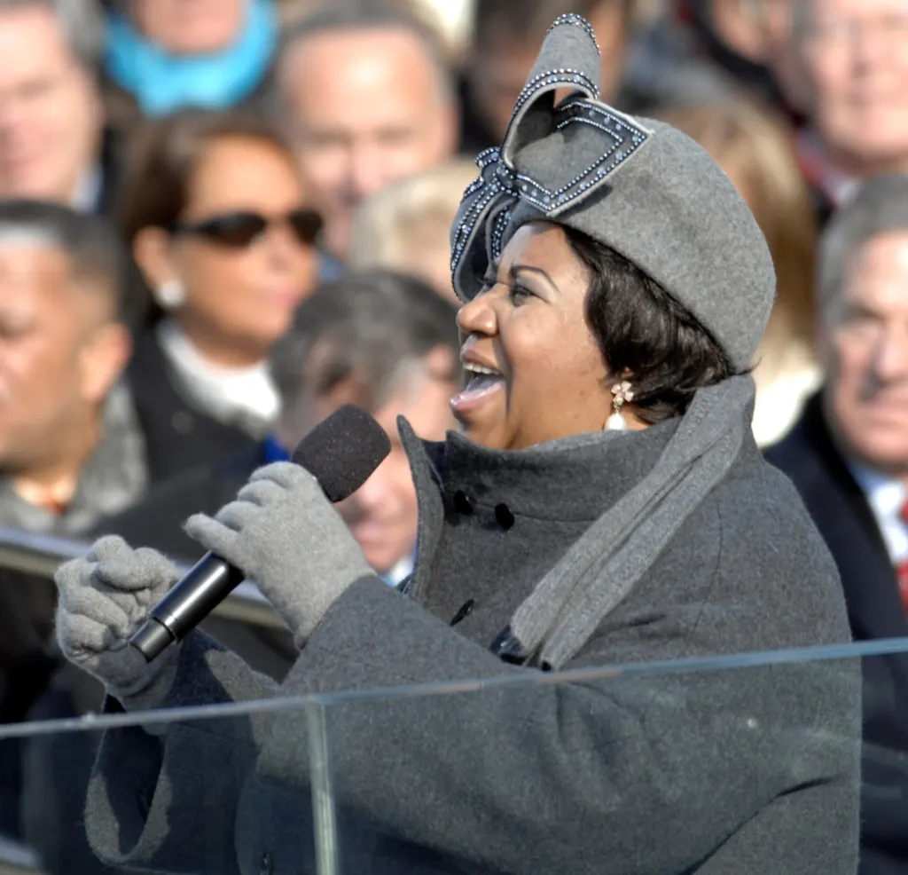 Aretha Franklin in a gray hat and coat singing at the U.S. Capitol during the presidential inauguration on January 20, 2009
