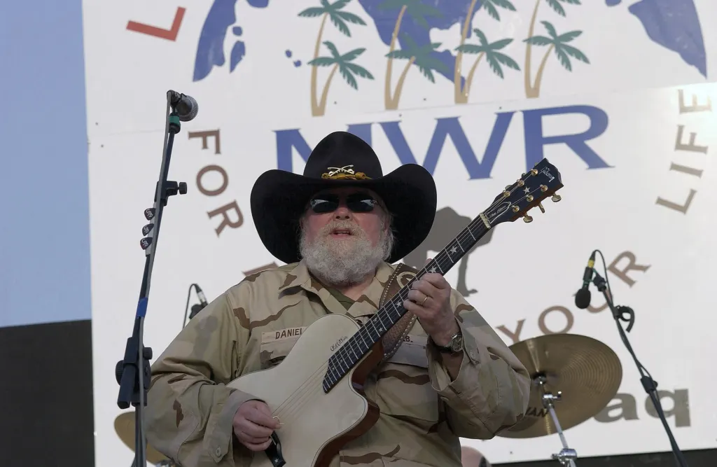 Charlie Daniels in a cowboy hat playing guitar on stage at a concert for US service members at Balad Air Base, Iraq