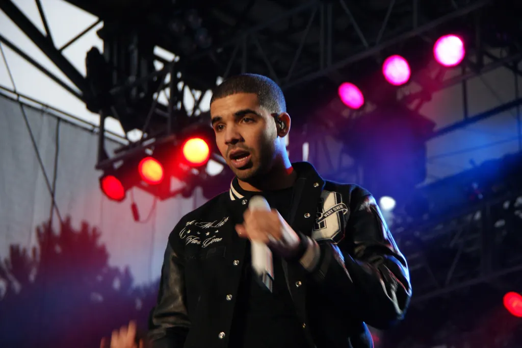 Drake performing on stage with a microphone in 2010