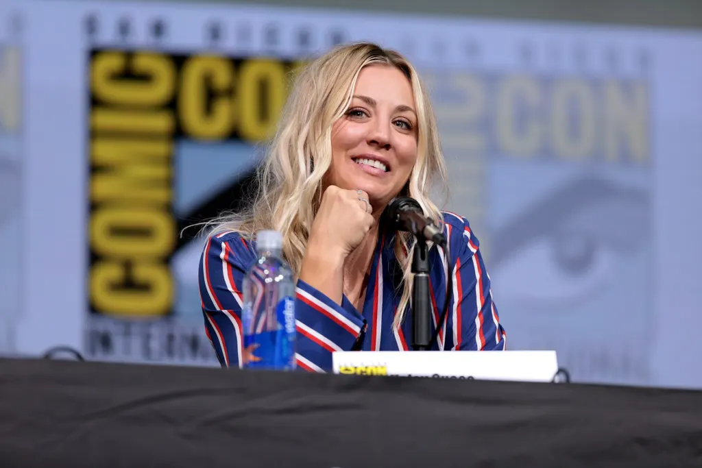 Kaley Cuoco speaking into a microphone on a panel at San Diego Comic-Con in July 2017