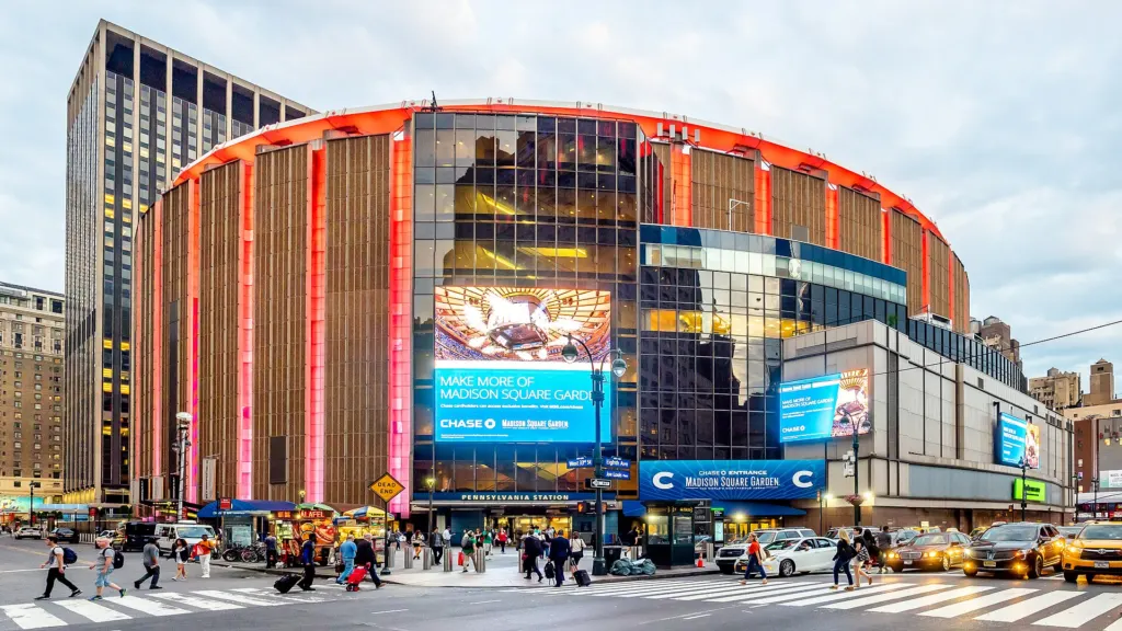 The round exterior of Madison Square Garden arena in Midtown Manhattan with its marquee screens and street traffic in front