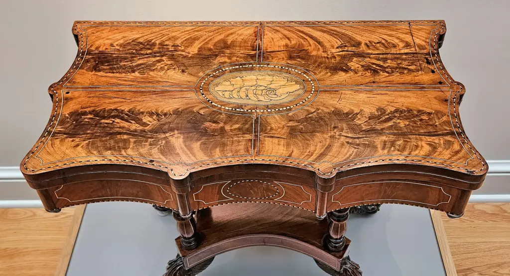 Top view of a mid-19th-century mahogany card table with satinwood and holly inlay on display at the Huntington in San Marino, California