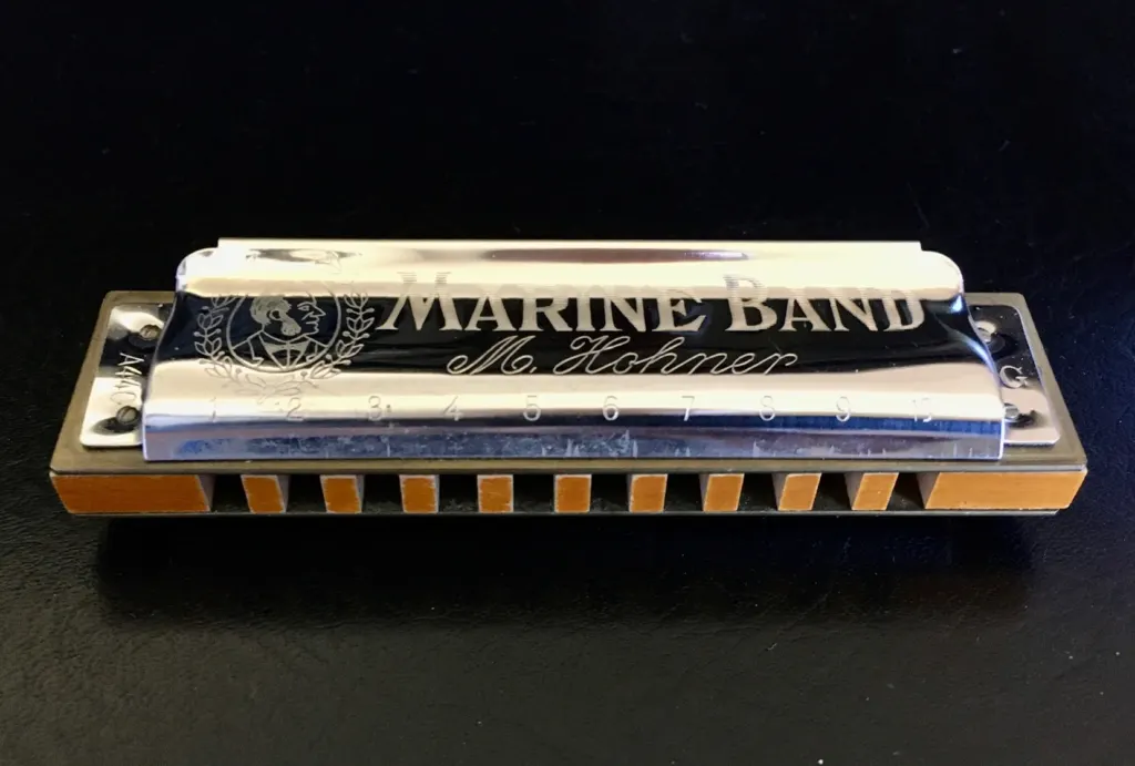 A Hohner Marine Band diatonic harmonica lying on a flat surface