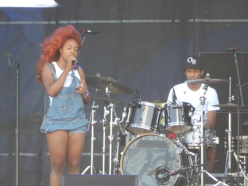 SZA singing into a microphone on stage at the Lollapalooza festival in Chicago in July 2015