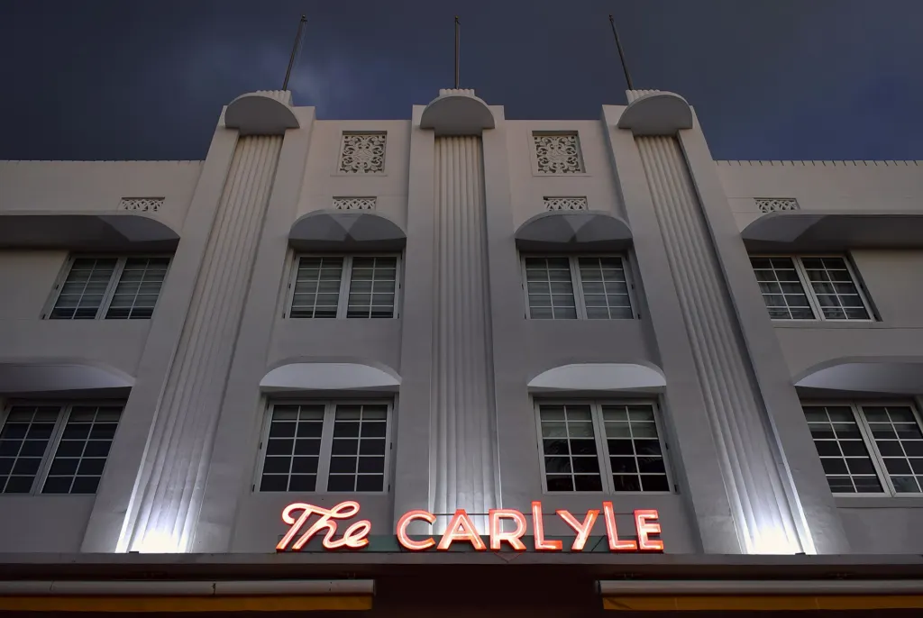 The neon sign of The Carlyle hotel in Miami Beach, Florida, seen from below