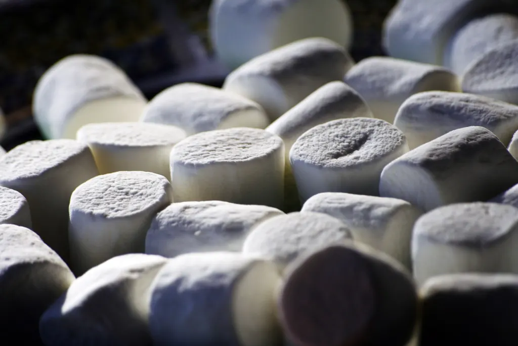 A close-up of a pile of plain white marshmallows