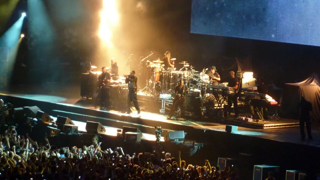Jay-Z performing on stage with a microphone under concert lights