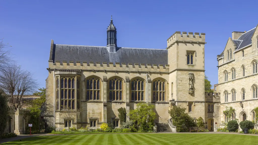 The stone hall of Pembroke College, Oxford, where Tolkien was a Fellow, seen across a striped lawn under a blue sky
