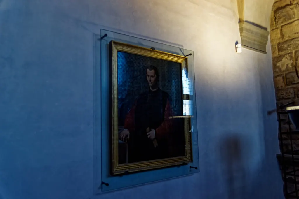 Santi di Tito's painted portrait of Niccolò Machiavelli in a dark robe, hanging in the Vecchia Cancelleria of the Palazzo Vecchio, Florence