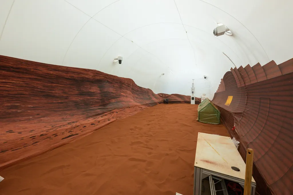 The red-sand simulated Martian landscape outside NASA's CHAPEA habitat at Johnson Space Center in Houston