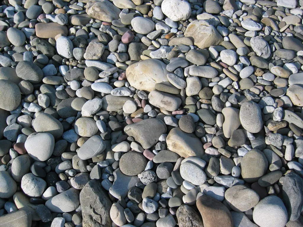 Smooth, rounded river stones in shades of gray, tan and red on a riverbed near Pincher Creek, Alberta