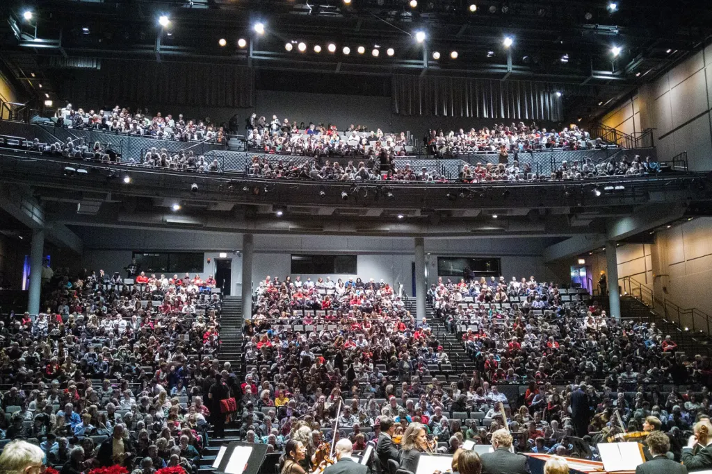 A packed audience fills the stalls and balcony of the Harris Theater in Chicago, seen from the stage during an intermission in December 2015