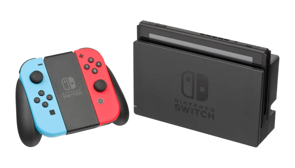 A Nintendo Switch console sitting in its dock with red and blue Joy-Con controllers attached