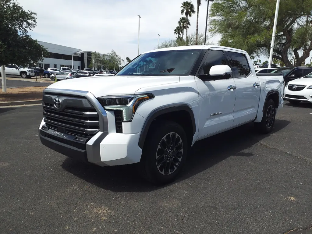 A white 2023 Toyota Tundra Limited crew-cab pickup parked on a dealership lot under palm trees in Mesa, Arizona
