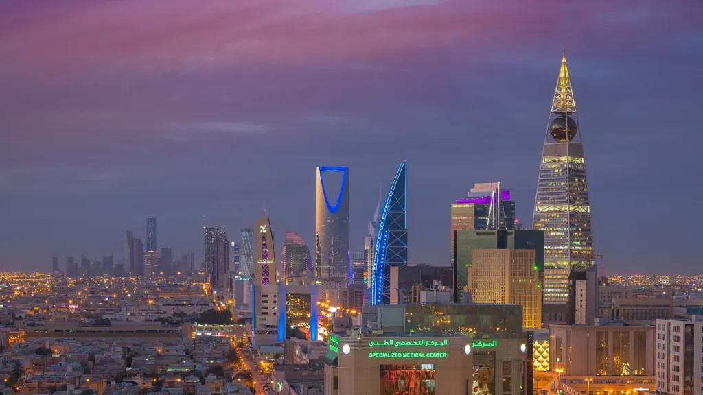 Riyadh's skyline at dusk in 2018, with the illuminated Kingdom Centre tower and other high-rises above the city lights
